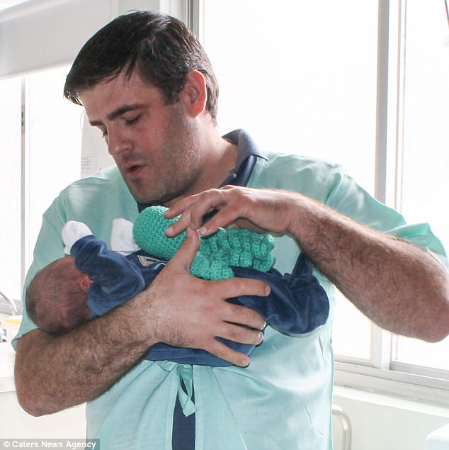 Le premier père, Murilo Ochile, 33 ans, est photographié avec l'un des jouets de pieuvre pour calmer son fils nouveau-né.